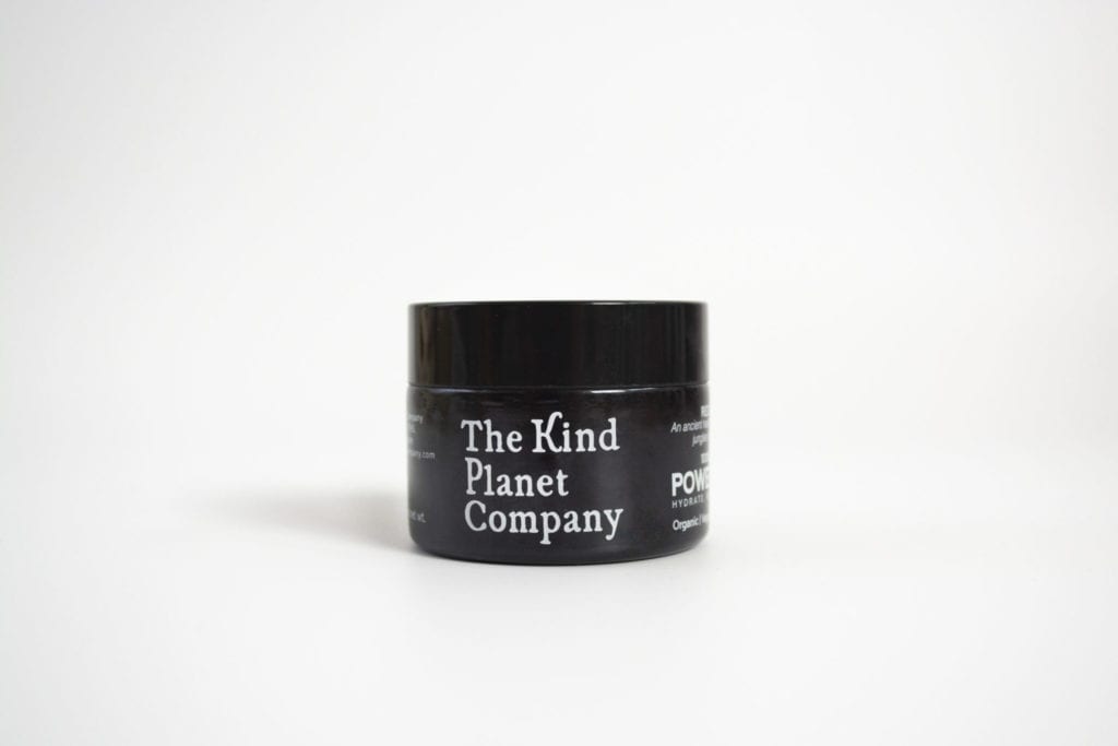 jar of power balm in amber glass with black lid