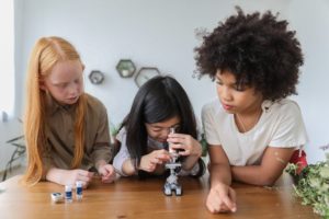 young girls looking through microscope
