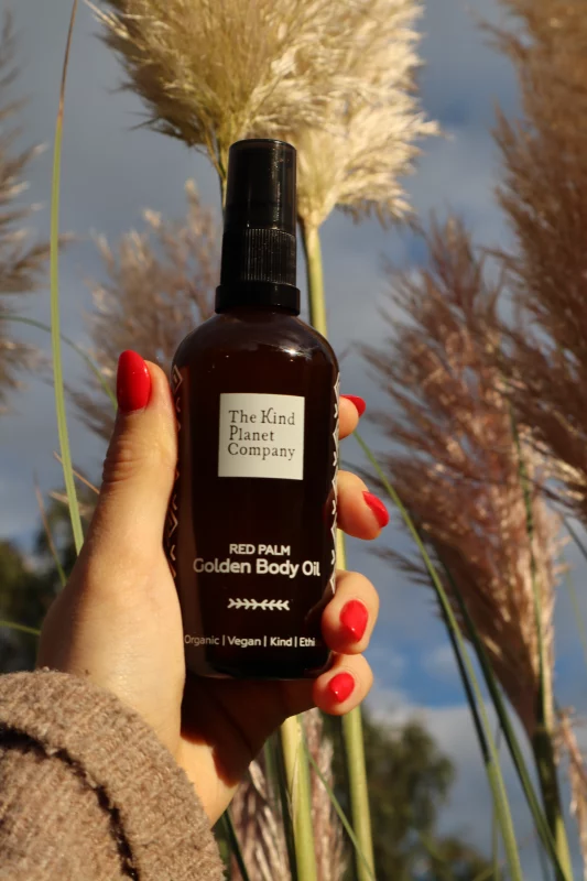 golden body oil with elephant grass in the background