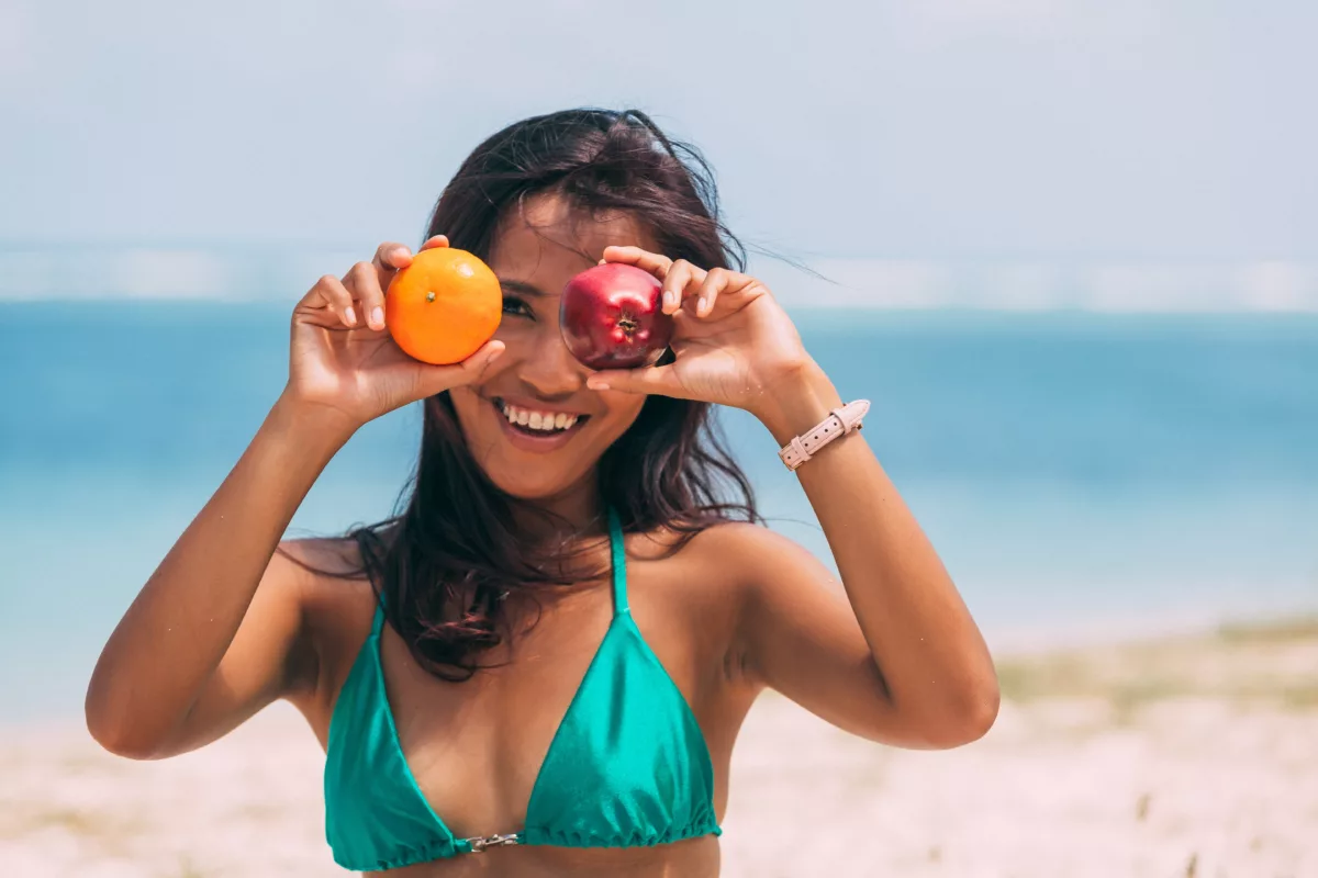 woman holding fruit to her face