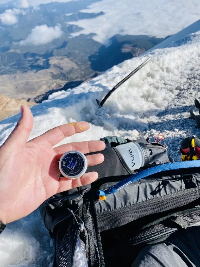 mini power balm held in hand on mountain